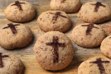 A batch of freshly baked mantecaos biscuits with a crucifix for Easter. clipart