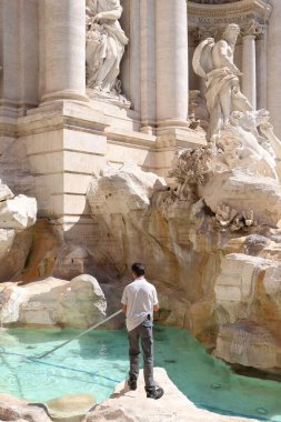 Roma, İtalya - 28 Haziran 2024: Trevi çeşmesini temizleyen bir işçi.