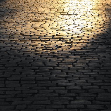 Terkedilmiş bir kaldırım taşı caddesinde sabah ışığı.