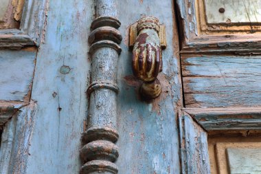 Yıpranmış metalik kapı tokmağı olan eski mavi bir kapı..