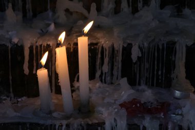 Sessiz, saygıdeğer bir Hıristiyan tapınma ortamında yanan üç mum. Mum ışığı inancı, duayı ve Tanrı 'nın varlığını sembolize eder. Ruhanilik, inanç, umut, yas veya sükunet teması için idealdir..