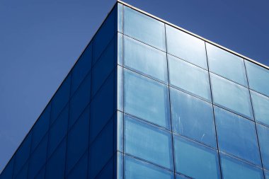 Eğik perspektifli mavi cam bir binanın parçası.
