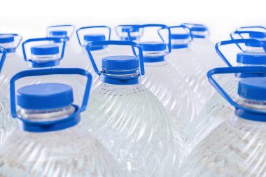 Beyaz arka planda plastik şişelerde su, izole edilmiş.