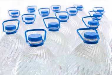 Beyaz arka planda plastik şişelerde su, izole edilmiş.