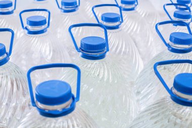 Beyaz arka planda plastik şişelerde su, izole edilmiş.