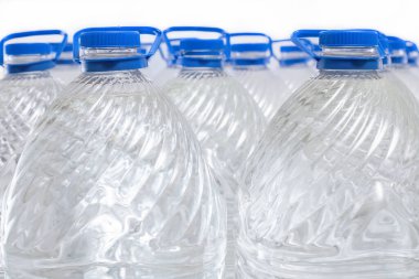 Beyaz arka planda plastik şişelerde su, izole edilmiş.