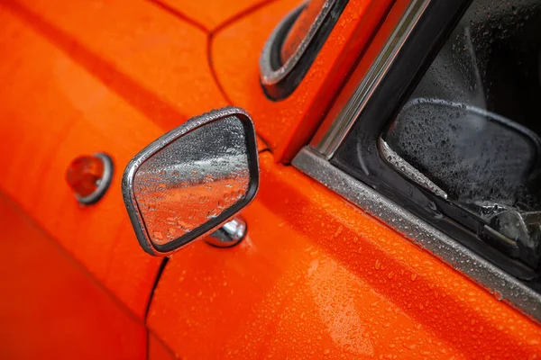 雨幕中一辆橙色复古汽车的后视镜 — 图库照片