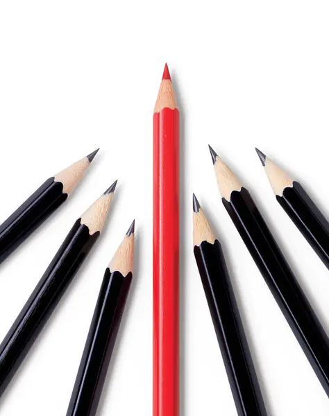 一支闪闪发亮的红色铅笔领着包装 在几支闪闪发亮的黑色铅笔前面指明了前进的道路 与白皙的阴影隔离 图库照片