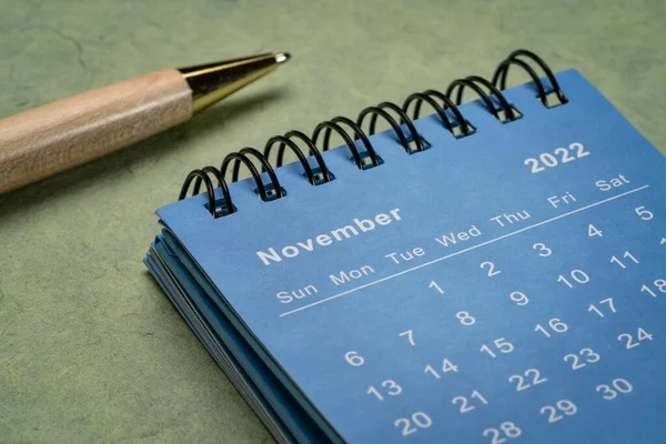 2022年11月 テクスチャ紙 ビジネスコンセプトに対してスタイリッシュなペンで小さなスパイラルデスクトップカレンダー — ストック写真