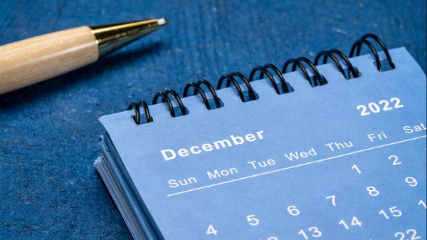 2022年12月 与蓝色纹理纸相对照的螺旋桌面日历 具有时尚的钢笔 低角度的射击 时间和商业概念 — 图库照片