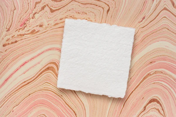 再生ジュート繊維で作られた赤い大理石の紙に対する空白の白いKhadi紙の小さな正方形のシート — ストック写真