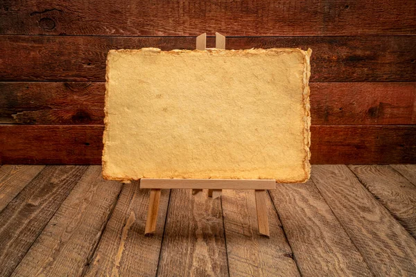 small easel sign with handmade yellow paper against rustic and weathered wood background