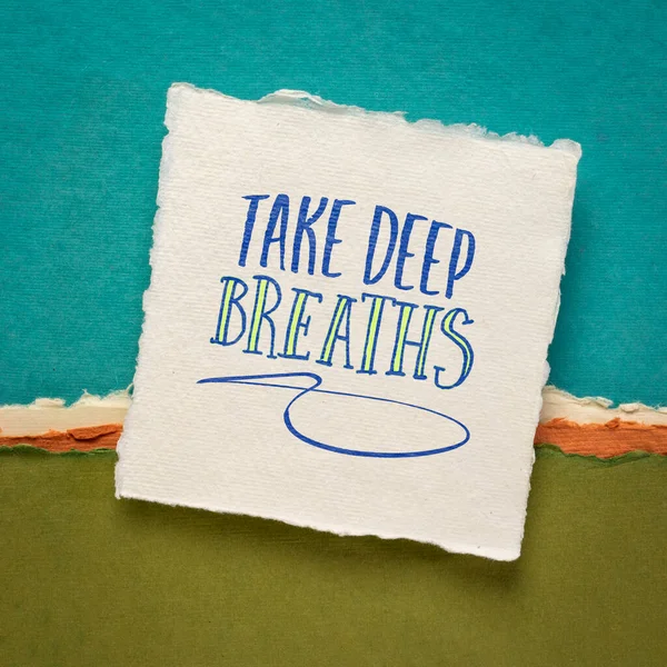 take deep breaths advice or reminder handwriting on a handmade paper against abstract landscape, self care, de-stress and relax concept