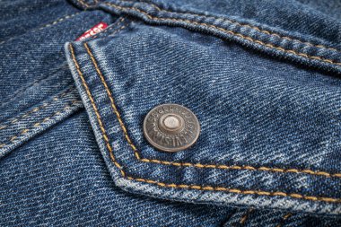 Fort Collins, CO, ABD - 14 Kasım 2022: Levi-Strauss kamyoncu ceketinde metal bir düğme. Levi Strauss & Co., Levis marka kot pantolonları ile dünya çapında tanınan bir Amerikan giyim şirketidir..