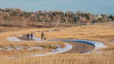 Fort Collins, CO, ABD - 30 Ocak 2022: Colorado eteklerindeki Cathy Prairie Doğal Arazisi 'nde sıcak ve sakin bir kış öğleden sonrasının tadını çıkaran aileler.