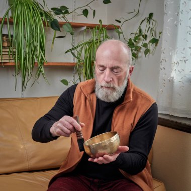 Son sınıf öğrencisi Tibet müzik kasesiyle meditasyon yapıyor. Ses terapisi konsepti.