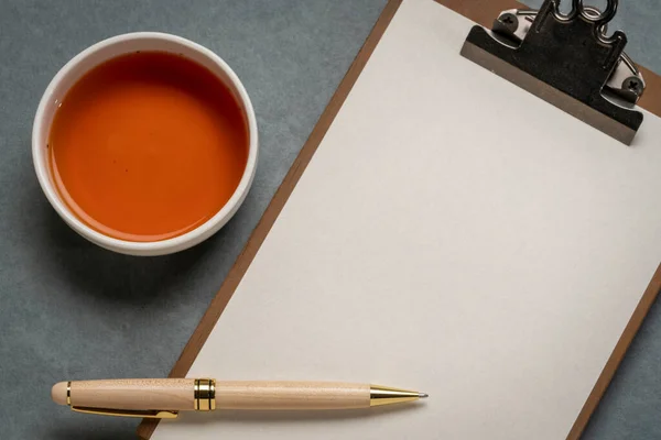 Boş Kağıtlı Bir Pano Bir Fincan Çay Şık Bir Kalemle — Stok fotoğraf