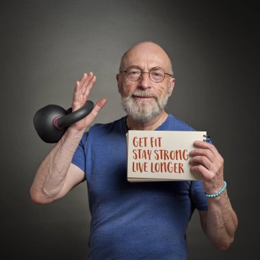 get fit, stay strong, live longer - motivational note held by a senior man exercising with a kettlebell