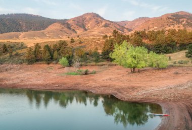 Yazın sonlarında sakin bir dağ gölünün üzerinde ayağa kalkın - Fort Collins, Colorado 'da Horsetooth Reservoir' da sisli gündoğumunda duman, fitness ve eğlence konseptiyle