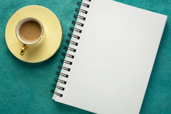 Caderno Esboços Espiral Branco Contra Papel Texturizado Com Uma Xícara — Fotografia de Stock