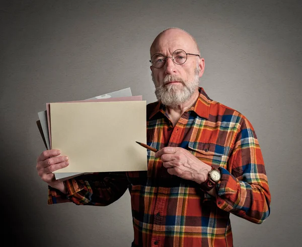 老年人手里拿着一张空白的纸和一支钢笔 一个演示或一个教学理念 — 图库照片