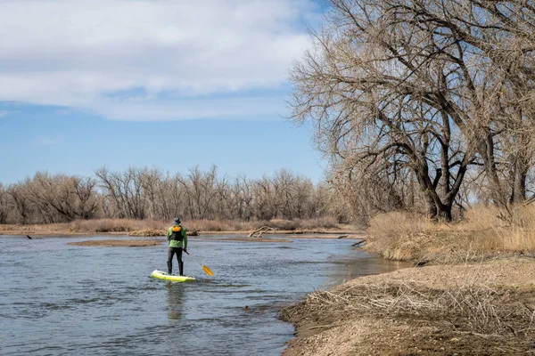 在科罗拉多州南普拉特河的早春风景中 资深男子站起来划桨 — 图库照片