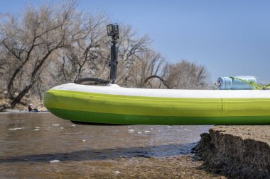 Evans, CO, ABD - 1 Nisan 2023: GoPro aksiyon kamerası Colorado 'daki South Platte Nehri' nin ilk bahar kürekleri üzerinde şişirilebilir stand up tahtasına monte edildi.