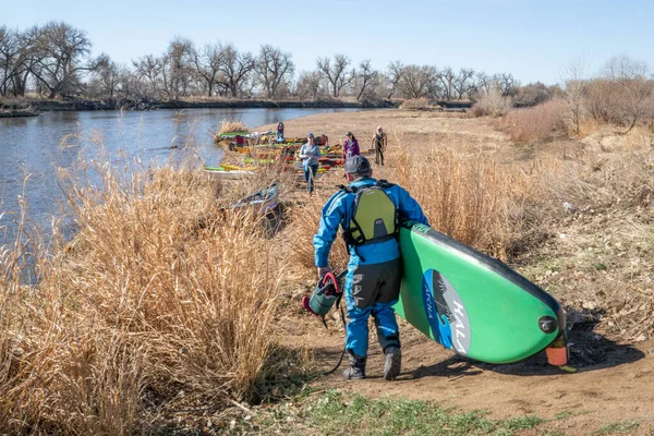 美国加利福尼亚州埃文斯市 2023年4月1日 身穿干衣的男子划桨手正在科罗拉多州的南普拉特河上提起他的站立划桨板 弹簧划桨 — 图库照片