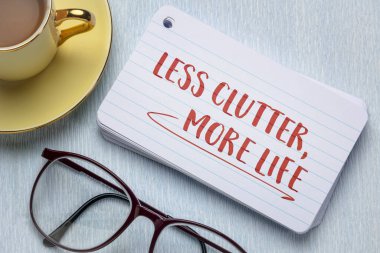 less clutter, more life - decluttering, minimalism and simplicity concept, handwriting on an index card clipart