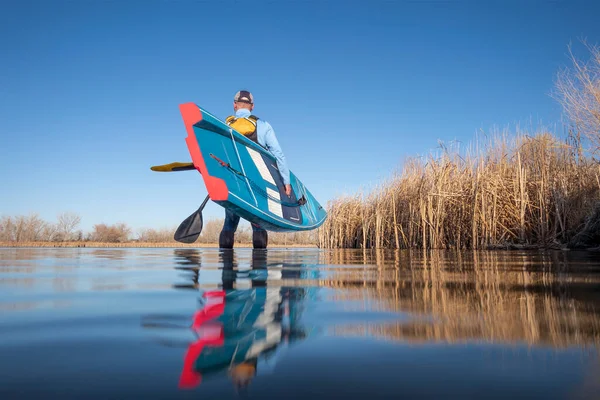 今年初春 资深男子划桨手将在平静的湖面上推出一个独立的划桨板 这是从水位上的一个动作相机看到青蛙的 — 图库照片