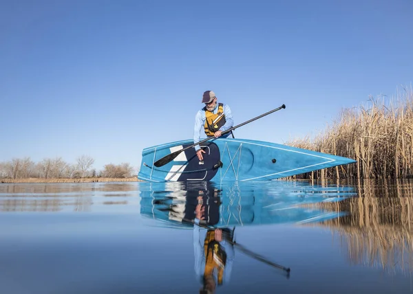 今年初春 资深男子划桨手将在平静的湖面上推出一个独立的划桨板 这是从水位上的一个动作相机看到青蛙的 — 图库照片