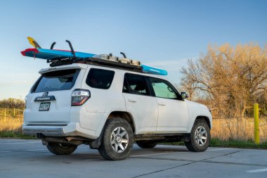 Gibbon, NE, ABD - 21 Nisan 2023: Toyota 4Runner SUV Nebraska 'da Platte Nehri kıyısındaki çatı raflarında ayakta duran bir raket (Sancak Su Hattı) ile.