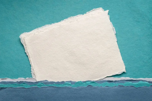 青い色調の抽象的な風景に対してインドからの空白の白いKhadiぼろ紙の小さなシート — ストック写真