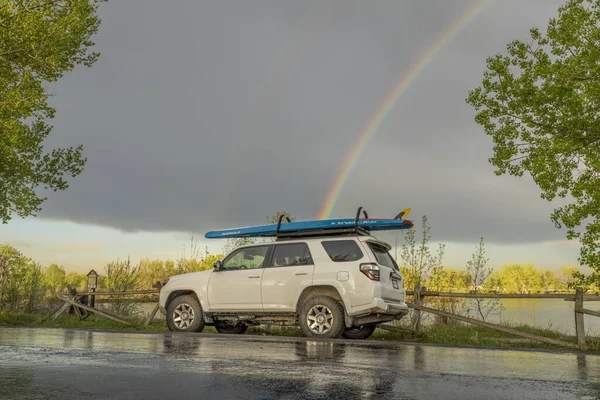 フォートコリンズ 2023年5月15日 虹と荒天下で湖をパドリングした後 ツアースタンドアップパドルボード スターボードによるウォーターライン とトヨタ4Runner Suv — ストック写真