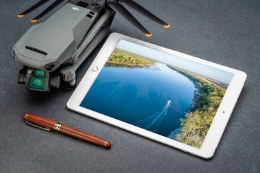 Fort Collins, CO, ABD - 20 Aralık 2021: Mavic 3, Missouri Nehri 'nin havadan görüntüsünü gösteren ipad tabletli bir DJI tüketici dronu.