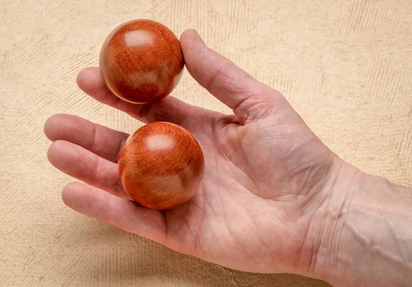 Male Hand Holding Pair Wooden Chinese Medicine Balls Textured Paper — Stock Photo, Image
