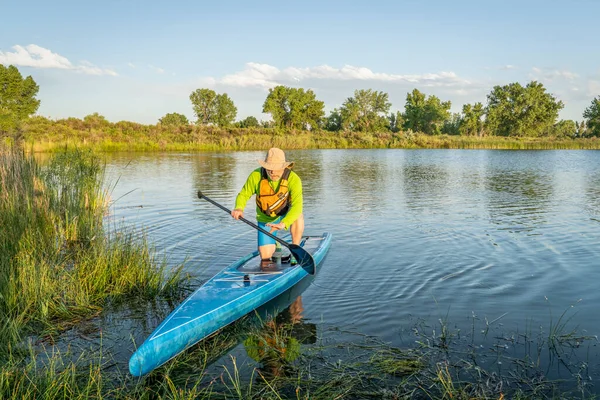 シニア男性スタンドアップ パドラーはコロラド州の夏の景色 — ストック写真