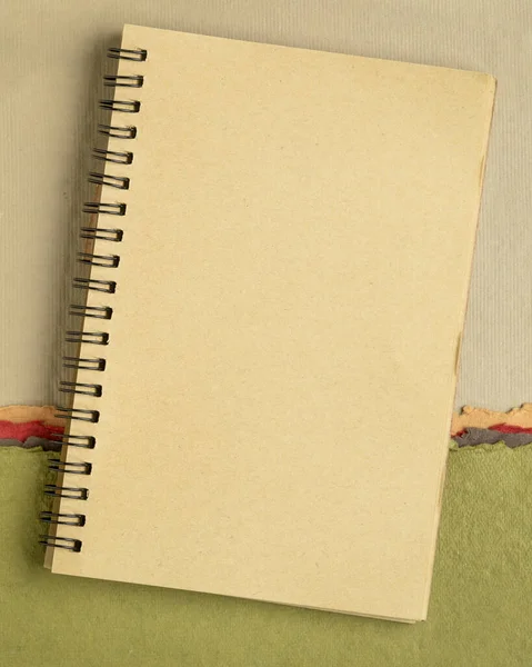 Blanco Spiraal Schetsboek Tegen Kleurrijk Abstract Papierlandschap — Stockfoto
