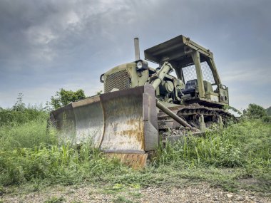 Eski terk edilmiş askeri buldozer bitki örtüsüyle kaplanmış.