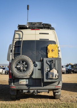 Lothe, CO, ABD - 27 Ağustos 2023: Mercedes Sprinter 4x4 karavan arkasında yedek lastik, çatı merdiveni ve farklı teçhizatlı raf.