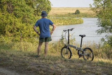Nebraska Ulusal Ormanı 'ndaki Whitetail Kampı' nda bisiklet sürdükten sonra Kasvetli Nehir 'e bakan son sınıf öğrencisi.