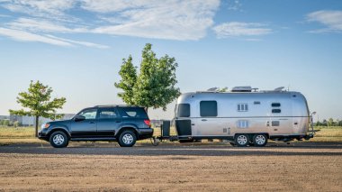 Loveland, CO, USA - August 27, 2023: Toyota Sequoia SUV with Aistream Trade Wind travel trailer at parking lot. clipart