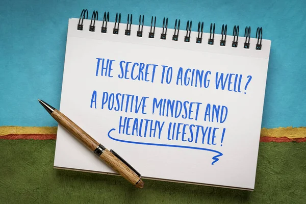 The secret to aging well? A positive mindset and healthy lifestyle! Inspirational note in a spiral notebook.