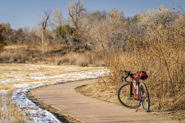 Fort Collins, Colorado 'da bisiklet yolunda çakıllı bisiklet turu. Sonbahar manzarasında kar ve kurumuş ayçiçekleri var.