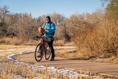 Fort Collins, Colorado 'da bisikletli bisiklet turu yapan yaşlı bir bisikletçi. Soğuk sonbahar havası ve biraz da kar var.