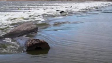 Mississippi nehri kıyısındaki kayalıklar zincirindeki alçak su barajında uzak beyaz su kayakçılarıyla büyük bir hız.