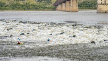 Granite City, Il, ABD - 8 Ekim 2023: St Louis, Missouri yakınlarındaki Kayalıklar Zinciri 'nde Mississippi Nehri' ndeki Low Water Barajı 'nın altında oynayan ve antrenman yapan iki beyaz su kayakçısı.