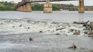 Granite City, Il, ABD - 8 Ekim 2023: St Louis, Missouri yakınlarındaki Kayalıklar Zinciri 'nde Mississippi Nehri' ndeki Low Water Barajı 'nın altında oynayan ve antrenman yapan iki beyaz su kayakçısı.