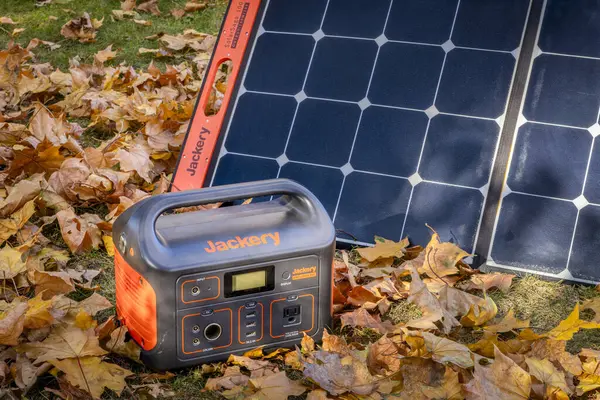 美国科林斯堡 2023年11月5日 Jackery Explorer 500 518Wh锂便携式电站在枫树干叶覆盖的土地上被太阳能电池板充电 — 图库照片