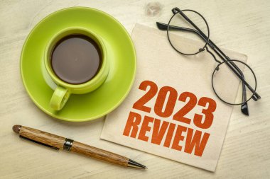 2023 yılı inceleme metni bir fincan kahveyle birlikte bir peçeteyle, yıl sonu iş konseptiyle.